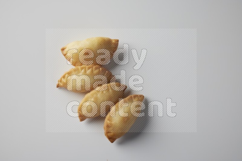 Four fried sambosa from a top angle on a white background