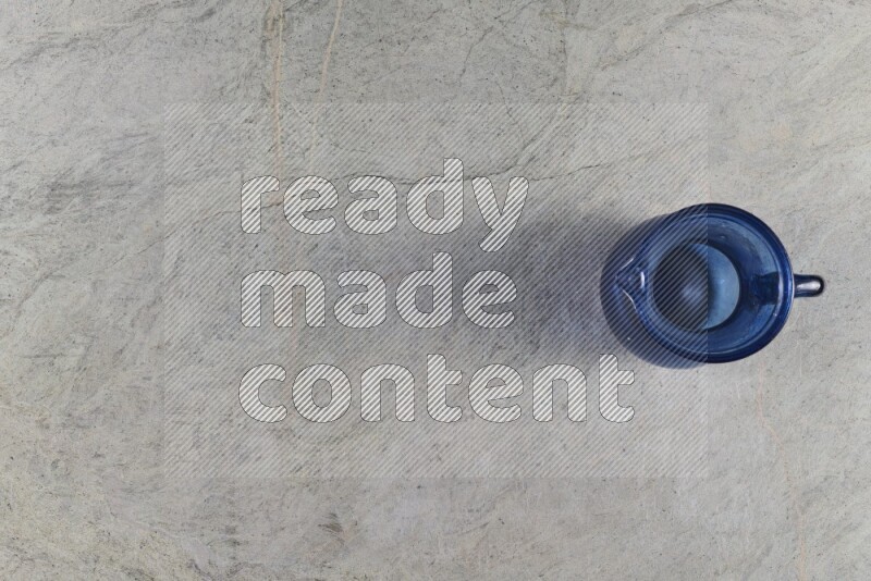 إبريق زجاجي فارغ على خلفية من الرخام الرمادي