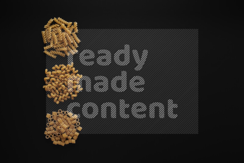 Different pasta types in 3 bunches on black background