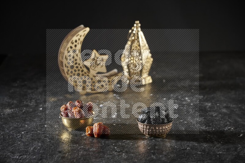 Dates in a metal bowl with dried plums beside golden lanterns in a dark setup