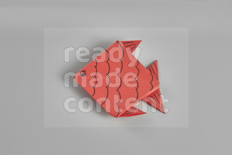 Origami fish on grey background