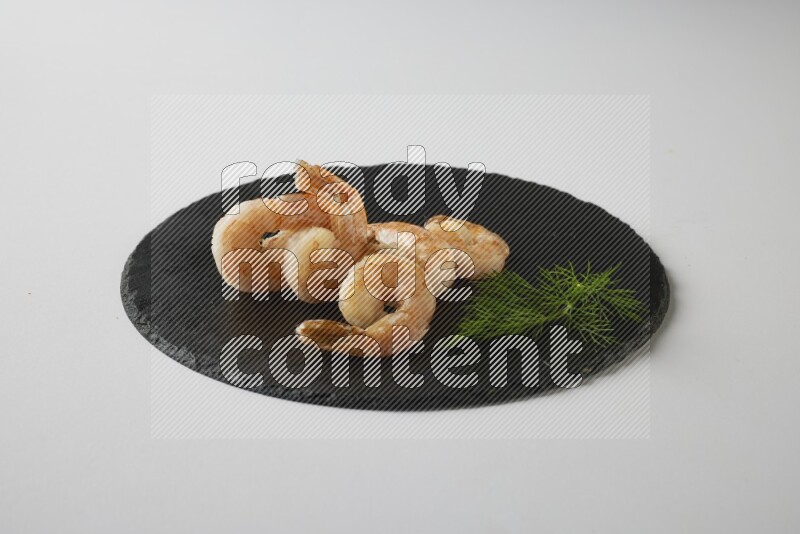 five grilled shrimps  on a black slate direct  on a white back ground
