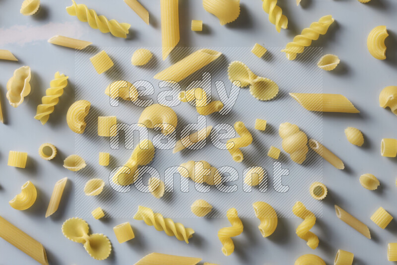 Different pasta types on light blue background