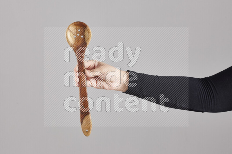 امرأة ترتدي عباءة سوداء تحمل أدوات خشبية مختلفة في أوضاع متعددة