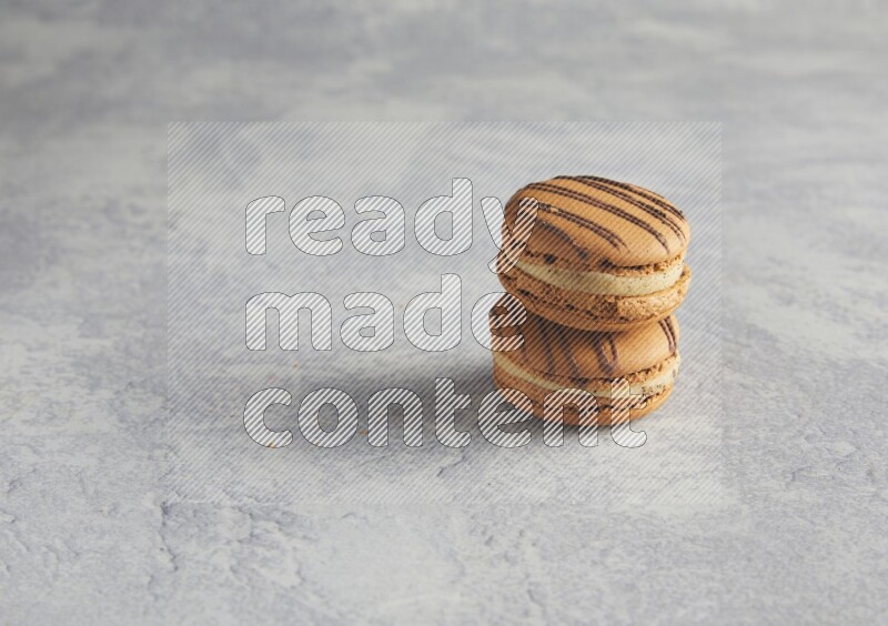 45º Shot of two light brown  Almond Cream macarons  on white  marble background