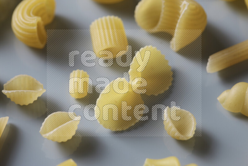 Different pasta types on light blue background