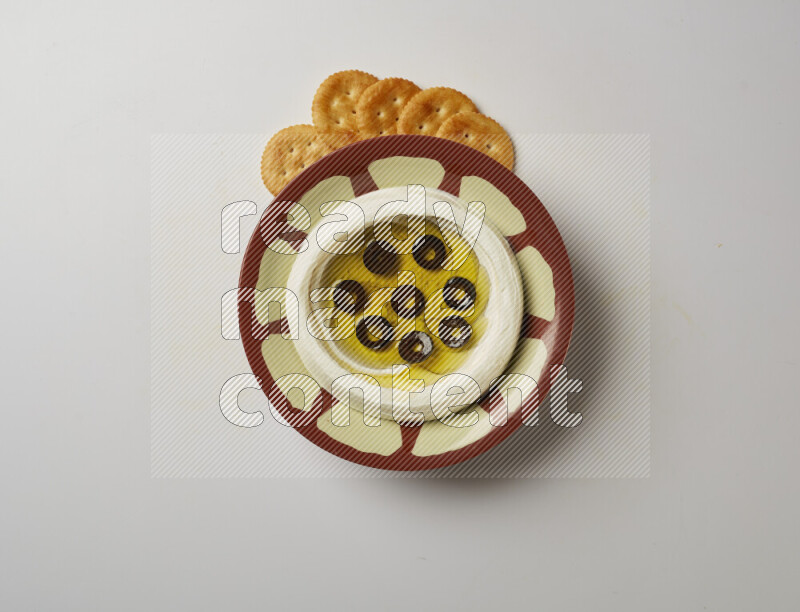 Lebnah garnished with sliced olives in a traditional plate on a white background
