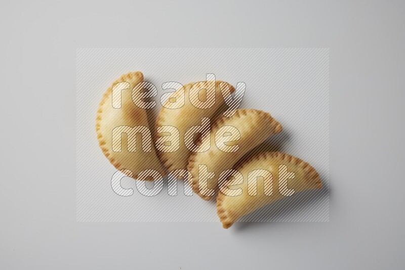 Four fried sambosa from a top angle on a white background