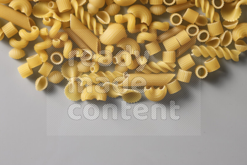 Different pasta types on light blue background