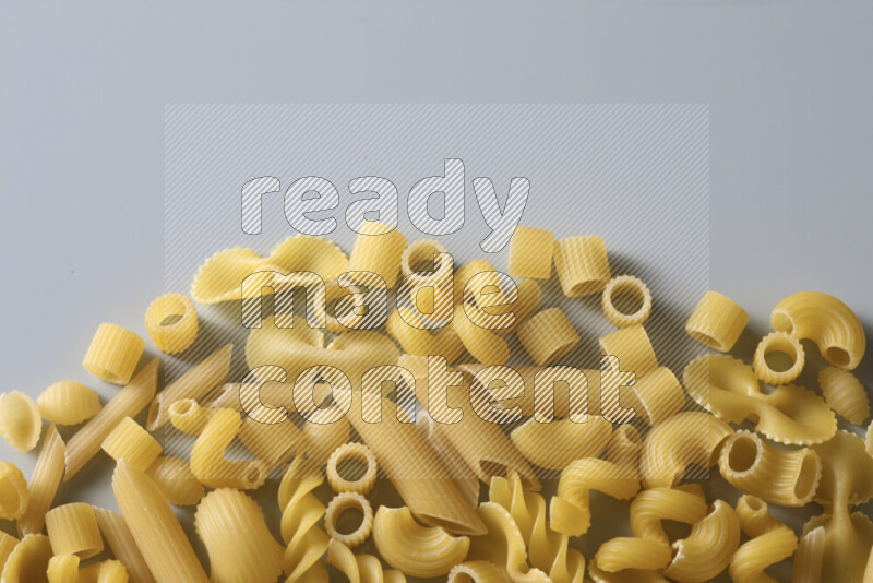 Different pasta types on light blue background