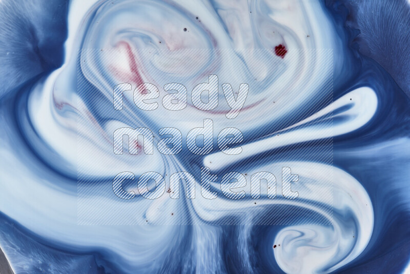 A close-up of abstract swirling patterns in blue, red and white