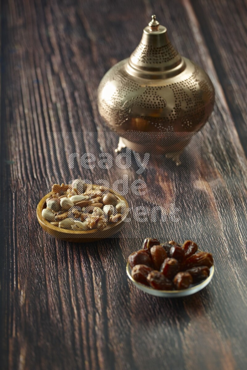 A golden lantern with different drinks, dates, nuts, prayer beads and quran on brown wooden background