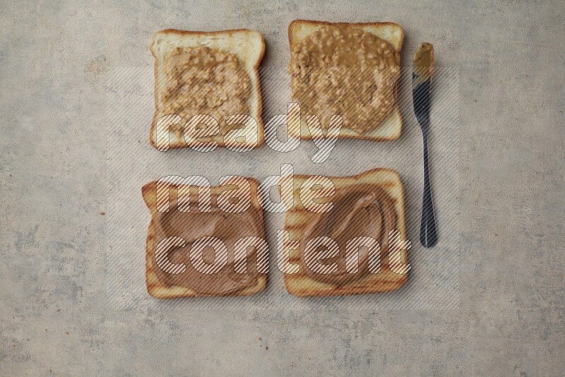 Creamy and crunchy peanut butter on a toasted white toast slices on a light blue textured background
