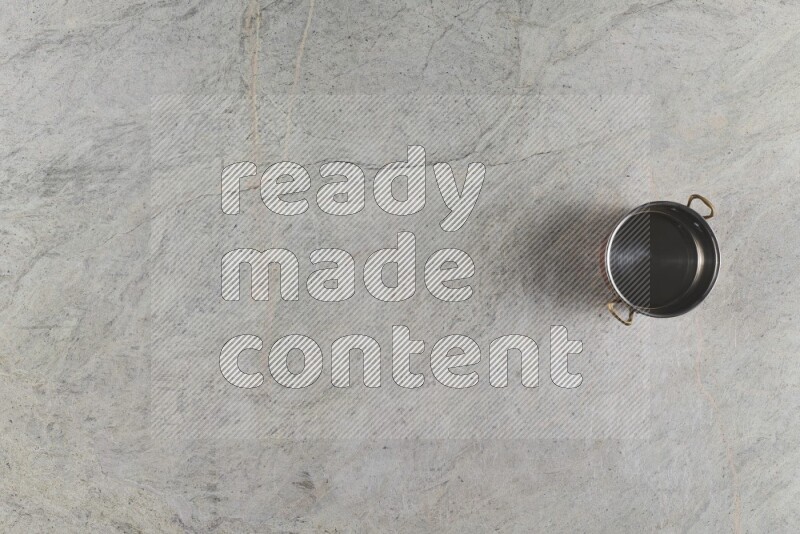 A small copper pot on grey marble background