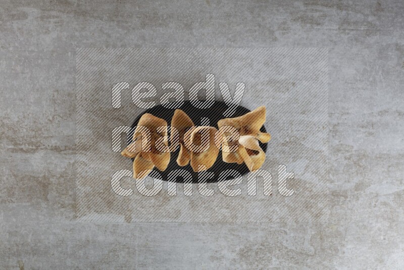 wonton cups on oval black ceramic plate on grey textured counter top
