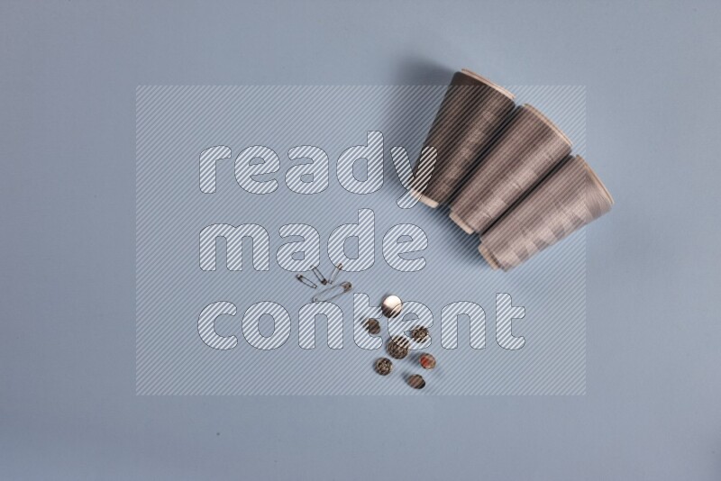 مجموعة من أدوات الخياطة والتفصيل رمادية اللون على خلفية زرقاء