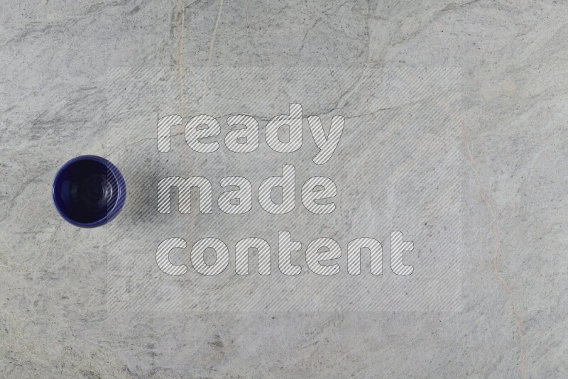 كأس فخاري متعدد الألوان على خلفية من الرخام الرمادي