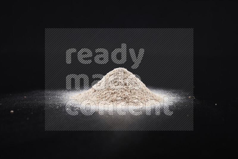 A bunch of onion powder on black background