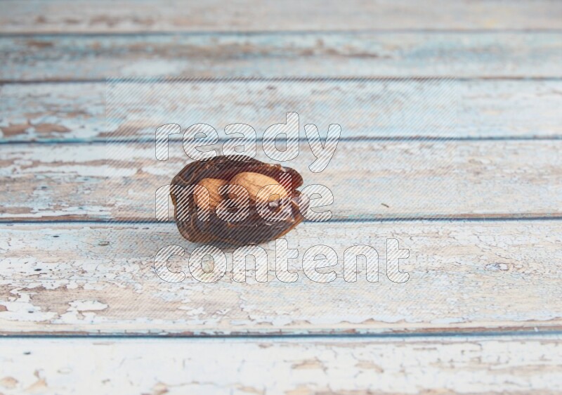 almond stuffed madjoul date on a light blue wooden background