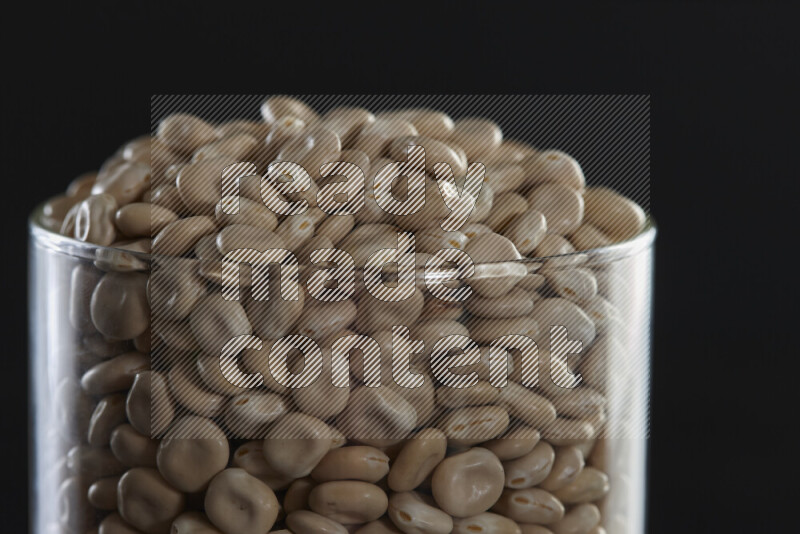 Lupin Beans in a glass jar on black background
