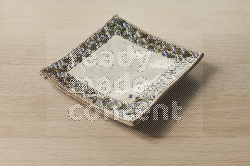 صحن فخاري مزخرف على خلفية خشبية فاتحة