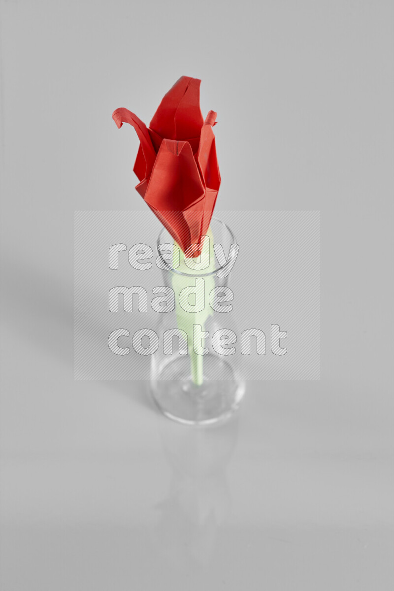 Origami flower on grey background