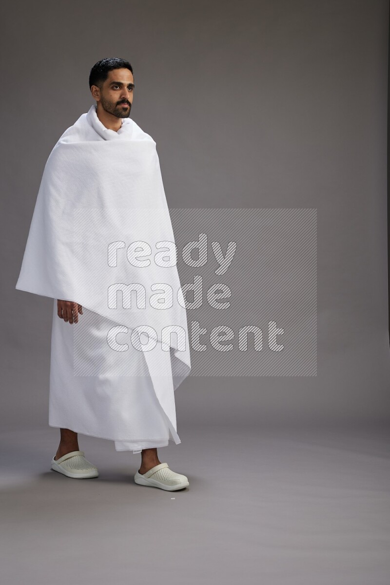 A man wearing Ehram Standing Interacting with the camera on gray background
