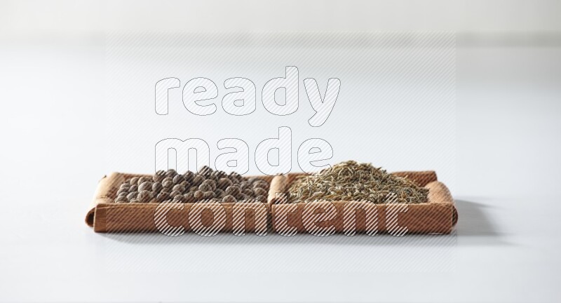 2 squares of cinnamon sticks full of allspice and cumin on white flooring