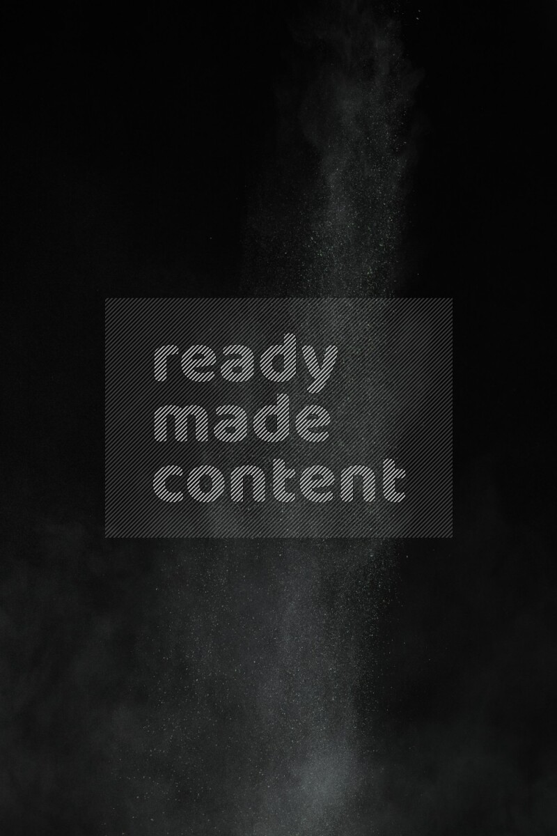 A side view of green powder explosion on black background