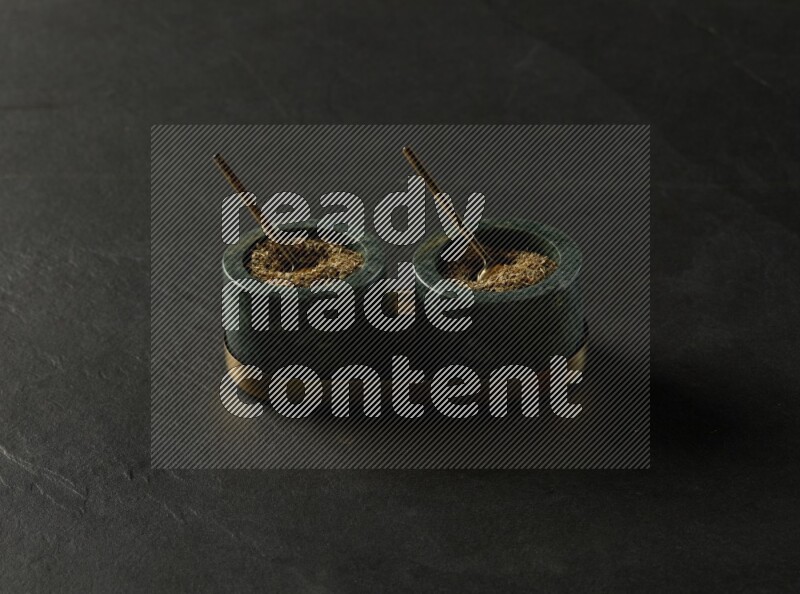 black and white round marble containers filled with herbs on gray textured countertop