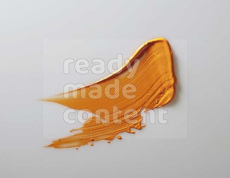An orange single curved painting knife stroke on white background