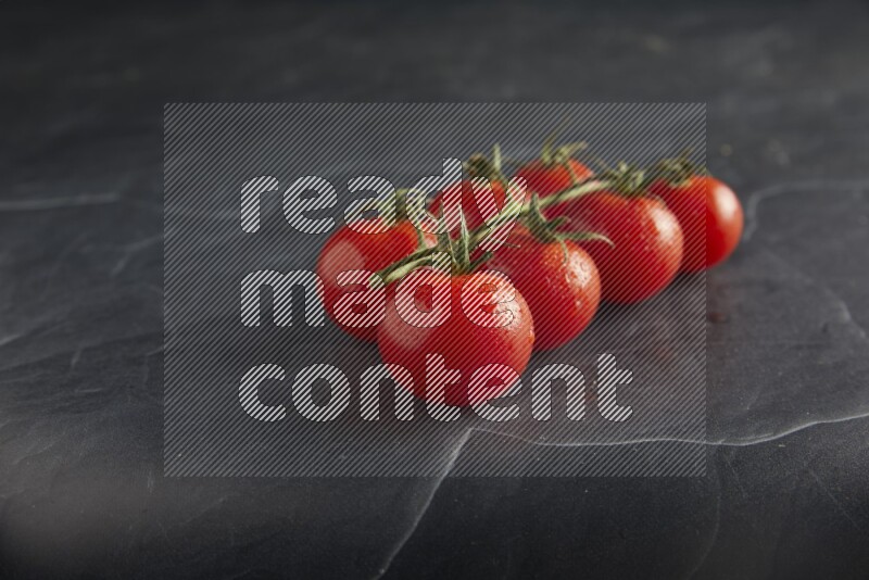 Red cherry tomato vein on a textured black slate background 45 degree