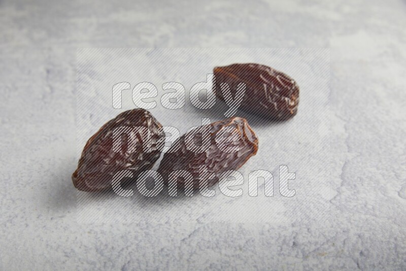 three madjoul dates on a light grey background