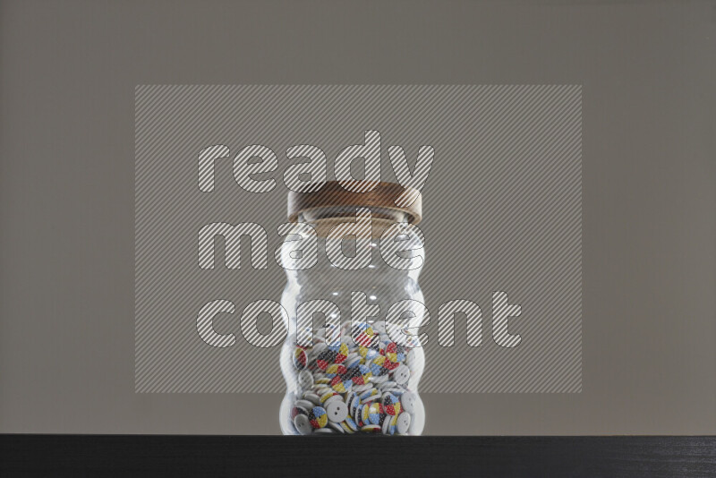 Buttons in a glass jar on black background