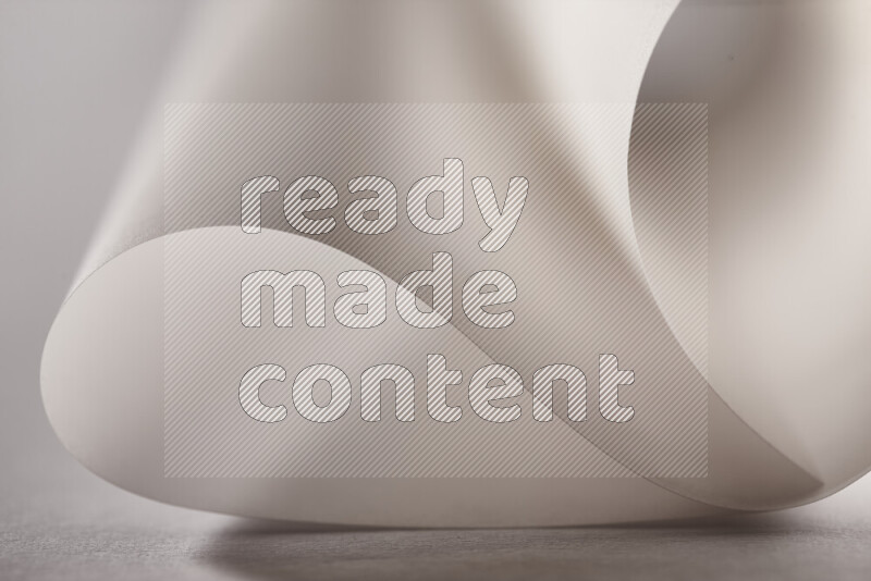 An abstract art piece displaying smooth curves in grey gradients created by colored light