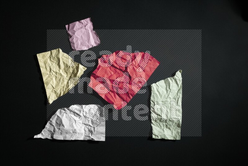 Crumpled multicolored paper on black background