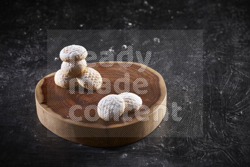 Kahk on a serving plate on a black background