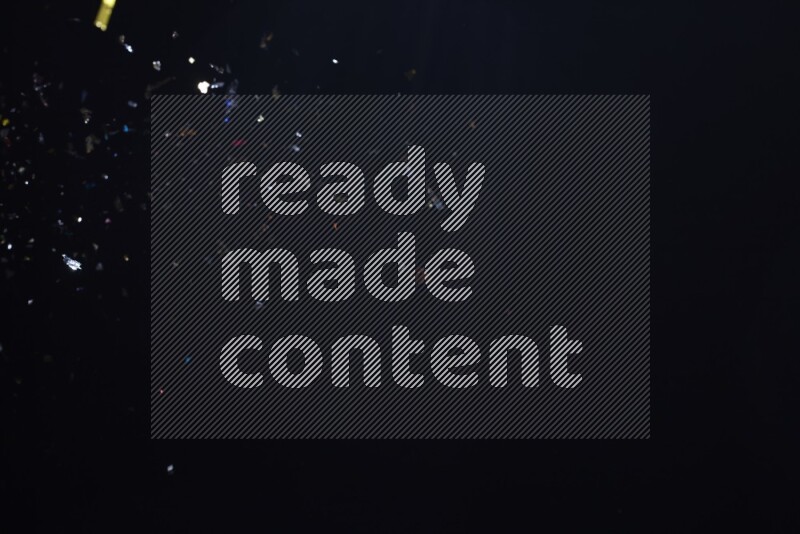 Falling multicolored confetti on black background