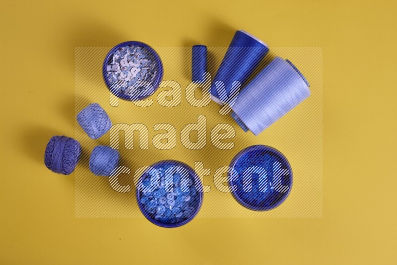A blue collection of sewing and tailoring tools arranged on a yellow background