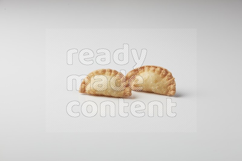 Two fried sambosas on a white background