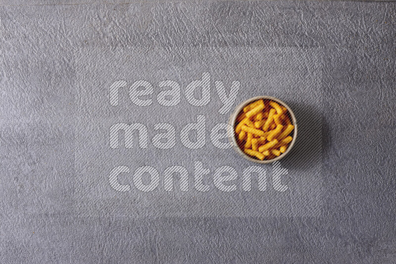 Assorted snacks in pottery bowls on grey background