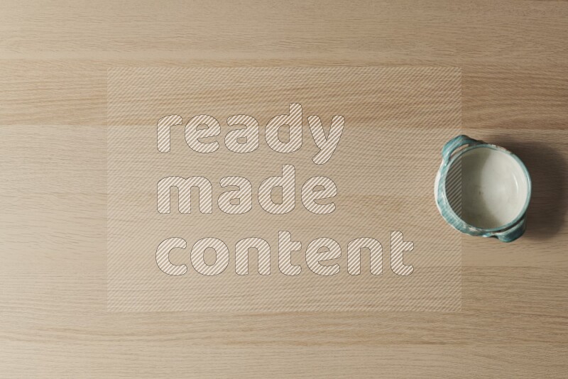 A multicolored pottery bowl on light wooden background