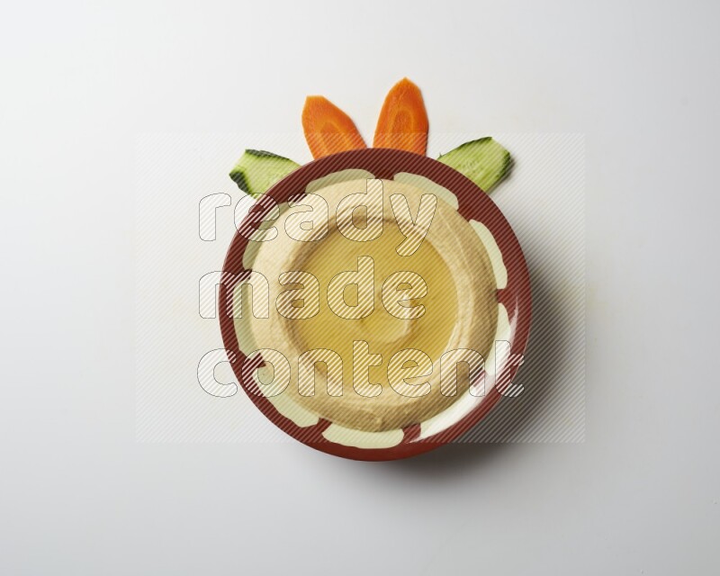 Hummus in a traditional plate garnished with olive oil on a white background