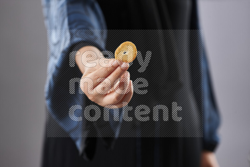 Woman in abaya holding different kinds of snacks in different positions