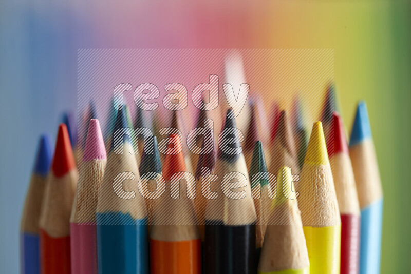 The image captures a close-up of sharpened colored pencils on multicolored background