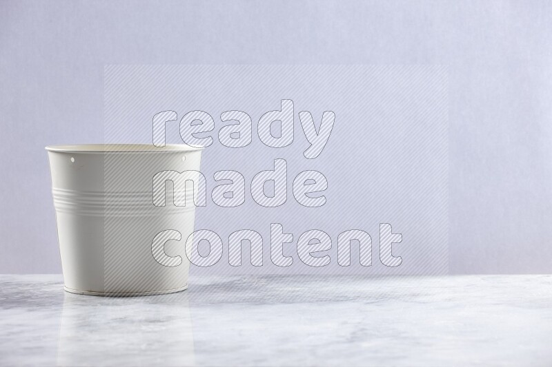 An empty white plant pot on grey marble background