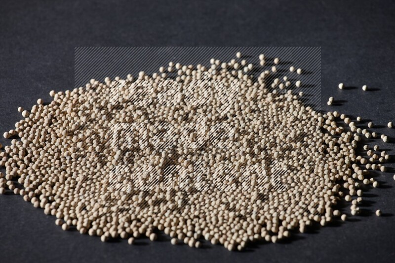 White pepper beads on black flooring