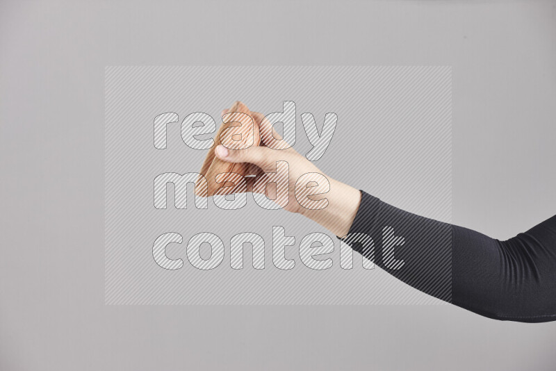 امرأة ترتدي عباءة سوداء تحمل أدوات خشبية مختلفة في أوضاع متعددة