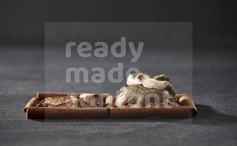 2 squares of cinnamon sticks full of cinnamon and ginger on black flooring