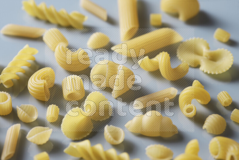 Different pasta types on light blue background